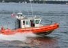 Coast Guard patrol boat speeding across a bay