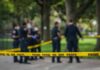 crime scene tape with police officers in a park