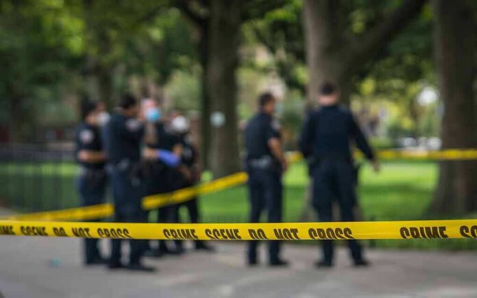 crime scene tape with police officers in a park