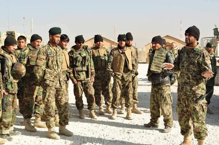 Soldiers in camouflage gather for a briefing outdoors
