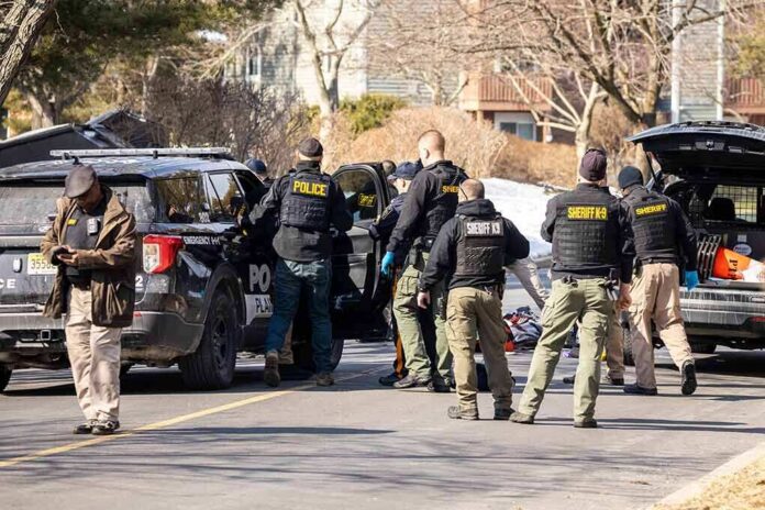 shutterstock_2126536382 Police and sheriff officers gather around vehicles on a suburban street