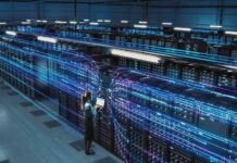Technician with laptop in a large data center aisle