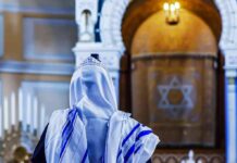 Shabbat Service Erupts Into Sudden Violence Person in white and blue prayer shawl facing ornate interior