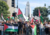 Protesters holding Palestinian flags gather in a city street