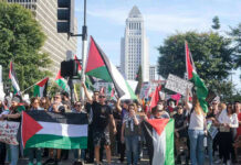 Protesters holding Palestinian flags gather in a city street