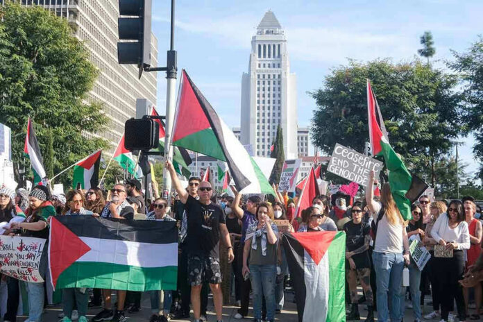 Protesters holding Palestinian flags gather in a city street