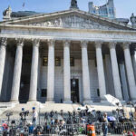 Donor Dollars, Rare Favor—What Changed? Reporters and photographers gathered outside a neoclassical courthouse