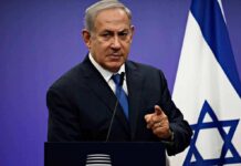Israel’s Political Map Is Suddenly Shifting Fast man in suit speaking at podium with Israeli flag