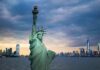Statue of Liberty with city skyline at dusk
