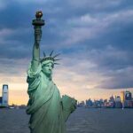 New York Is Picking Up The Pieces Statue of Liberty with city skyline at dusk