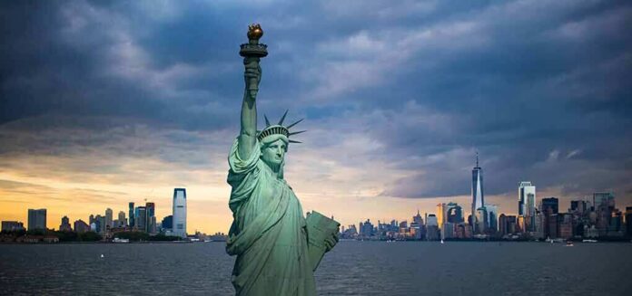 Statue of Liberty with city skyline at dusk