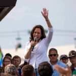 Kamala Harris speaking at outdoor rally, Paul Scholes in the crowd