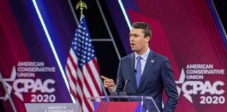 Speaker in suit at CPAC podium on stage