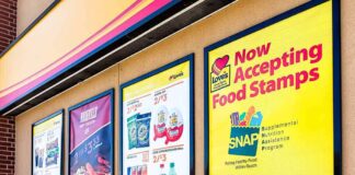Store window posters advertising SNAP EBT acceptance and product deals