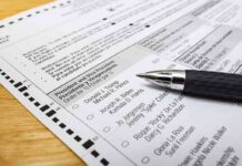 Ballot paper with pen on wooden surface