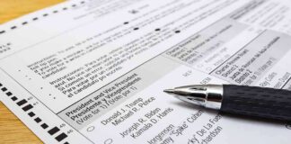 Ballot paper with pen on wooden surface