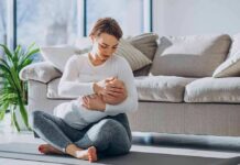 Mother breastfeeding baby on living room floor