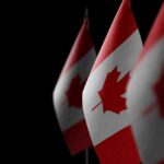 Canadian flags with maple leaf on dark background