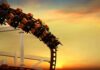 roller coaster train rounding a curve at sunset
