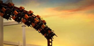 roller coaster train rounding a curve at sunset