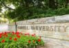 1,200 Reports, Seven Expulsions. What Happened? Cornell University stone entrance sign with red flowers