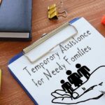 Immigration Arrests Trigger a New Taxpayer Fund Clipboard with TANF form and family icon on desk