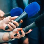 America First Twist: Dem Gets Tucker Nod Reporters holding colorful microphones