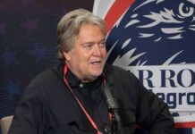 man speaking into a microphone at an event booth