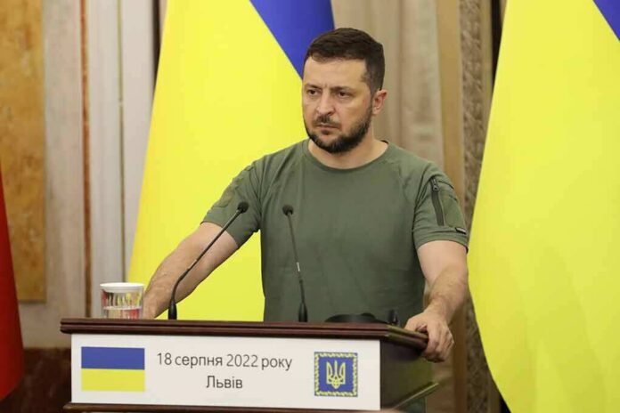 Man at a podium with Ukrainian flags