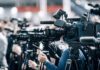 Emergency Declared: Homes Red-Tagged Broadcast cameras on tripods at a press event