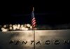 Small American flag on a memorial with bokeh lights at night