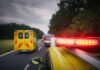 Emergency vehicles with flashing lights on a rural road