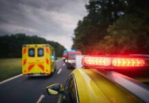 Emergency vehicles with flashing lights on a rural road