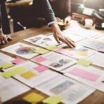 Team collaborating over documents and sticky notes on a desk