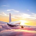 A New Danger Is Filling Russia’s Skies Airplane flying above clouds at sunrise
