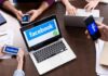Laptop with Facebook on screen surrounded by smartphones