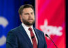 Crackdown Hits Outsourcing Giants Man in suit speaking at a podium with microphone