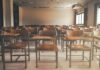 Empty classroom with rows of wooden desks and chairs