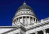 Capitol building dome with columns against a deep blue sky
