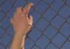 Prison Breach Stuns Tennessee – Killer Loose Hand gripping a chain-link fence
