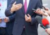 Family Claim Ignites National Security Firestorm Businessperson in suit speaking to reporters with microphones