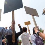 Group of people holding protest signs outdoors