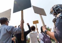 Spain Erupts After Rent Freeze Killed Group of people holding protest signs outdoors