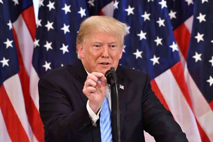 Donald Trump speaking at a podium with American flags in the background