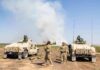Soldiers with two military vehicles during field exercise