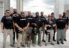 Group of law enforcement officers with tactical gear and a K9
