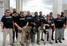 Group of law enforcement officers with tactical gear and a K9