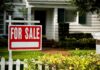 For sale sign in front of a suburban house