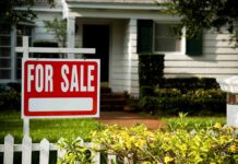 For sale sign in front of a suburban house