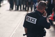 Police officer in uniform communicating with a crowd in an urban setting